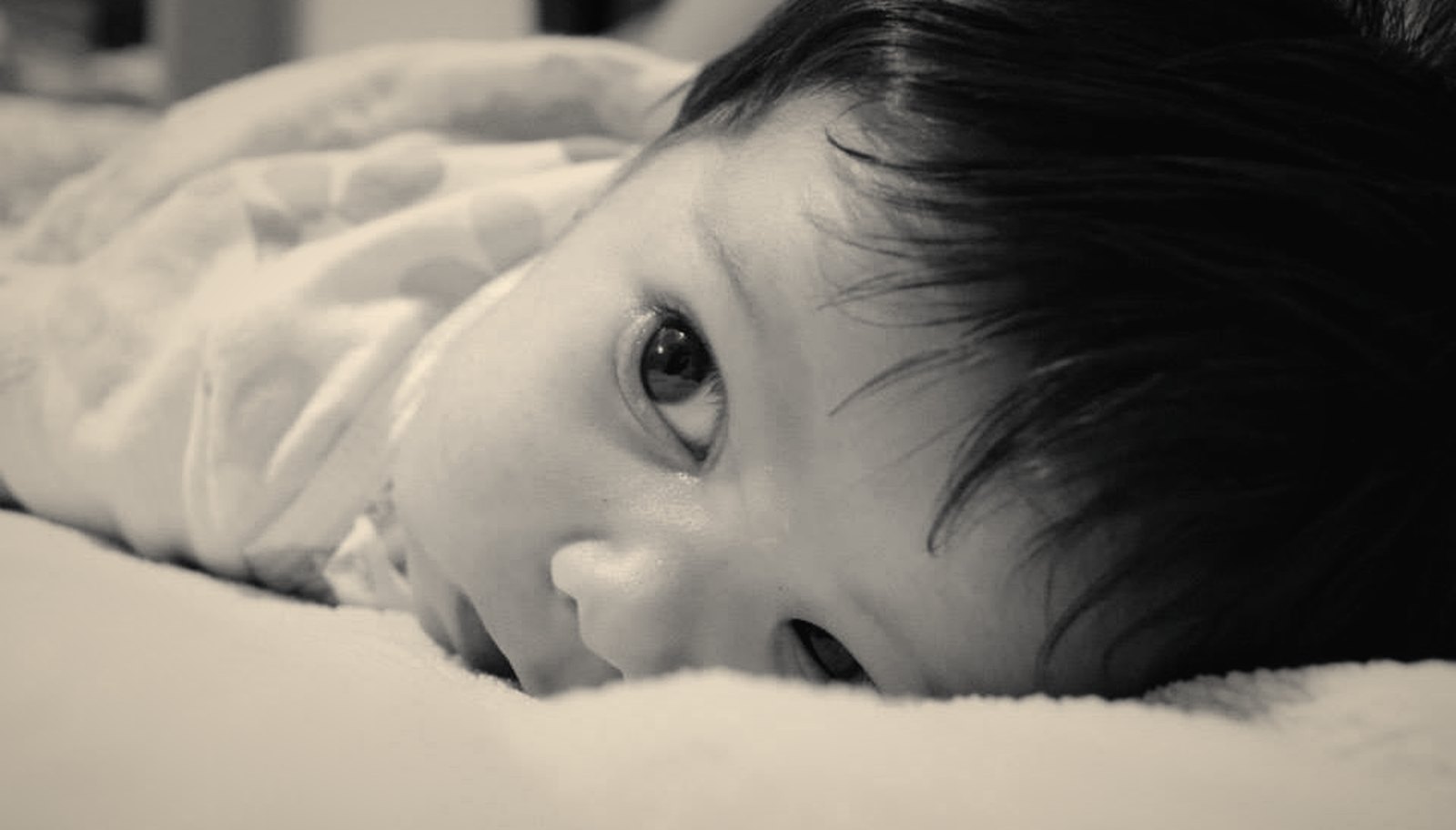 A sleeping baby resting on soft blankets, photographed close up