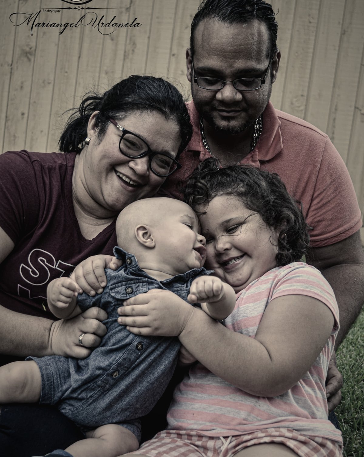A family laughing together while holding their children